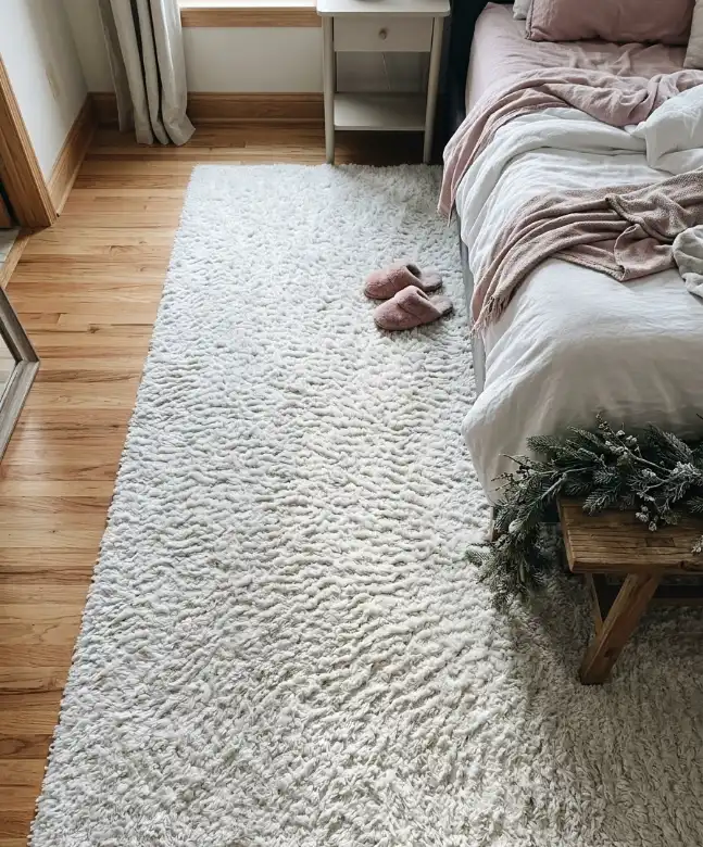 Fluffy white rug beside the bed